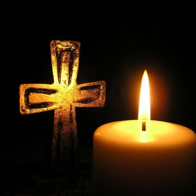golden-cross-and-candle-in-dark-surroundings